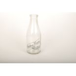 An Austins Dairy glass milk bottle, 'THE ARCADE PENZANCE TELEPHONE 800', height 25.5cm.
