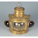 A yacht brass lamp with a bowed glass flanked by port and starboard lamps,