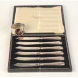 A set of six cake knives with filled silver handles together with a silver napkin ring with a