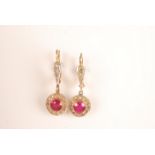 A pair of French gold earrings each with a ruby surrounded by diamonds.