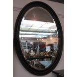 A gilt oval wall mirror, the frame decorated with foliage,