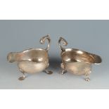 Two silver sauce boats in mid 18th century style one with shell cast feet. 14.7oz.