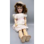 A porcelain head doll by Simon and Halbig, the head with sleep eyes, open mouth and teeth,