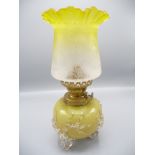A yellow glass oil lamp and shade, height 29.5cm.