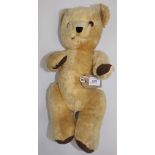 A gold plush Kapok filled teddy bear with felt paws, stitched nose and plastic eyes,