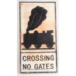 An iron rectangular road sign cast with a steam locomotive above the wording 'Crossing No Gates',