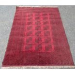 An Afghan carpet, with seven rows of three octagonal medallions, within multiple borders,