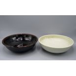 A Winchcombe Pottery bowl, with tenmoku glaze, diameter 27cm and a cream ground bowl, diameter 26.