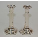 A pair of modern filled silver Georgian style plain candlesticks with circular bases and detachable