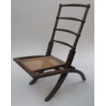 An Arts and Crafts folding chair, the back with four horizontal bar splats, above a rattan seat,