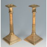 A pair of Georgian brass candlesticks, each with a part fluted stem and stepped base, height 26cm.