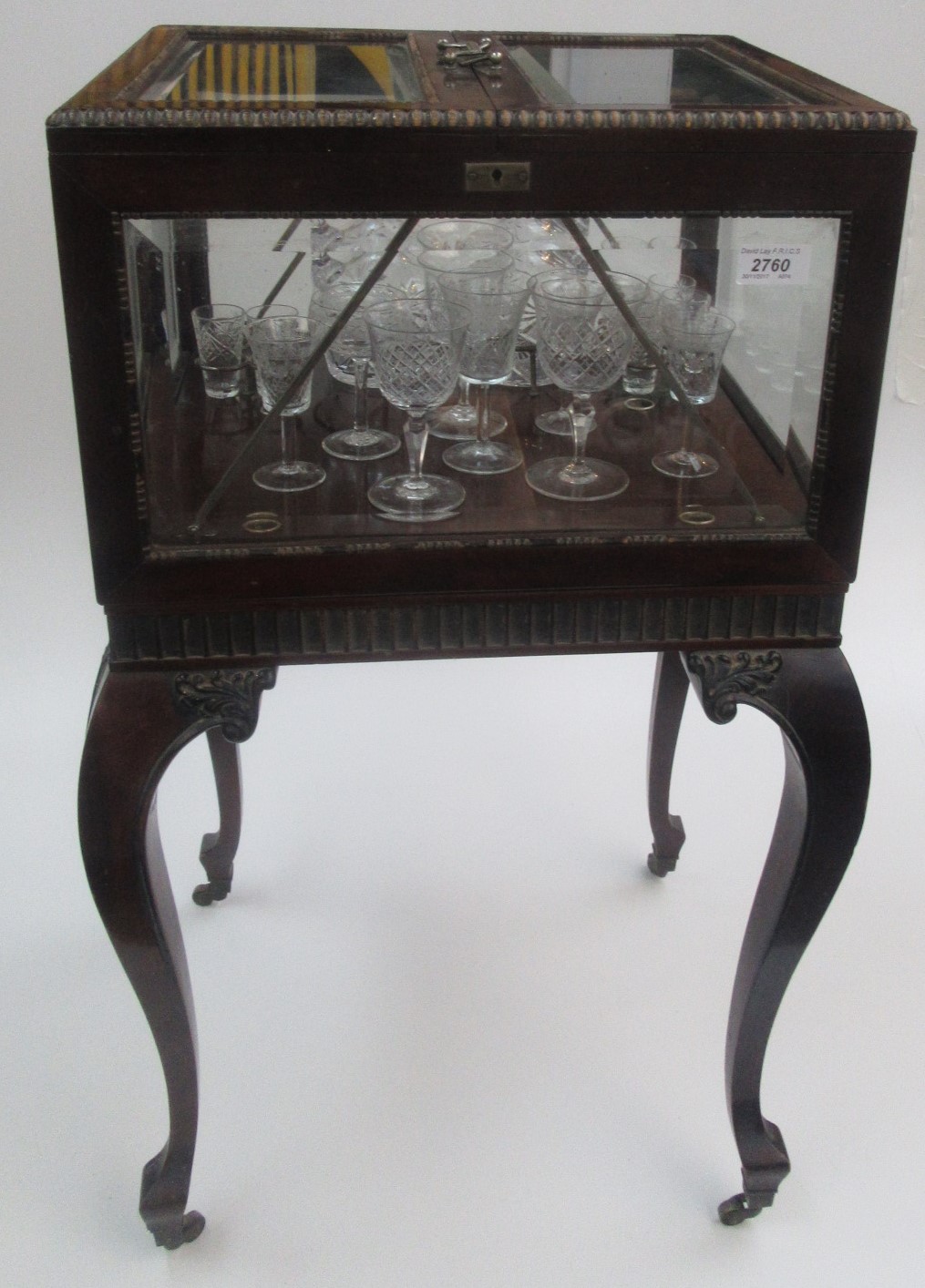 An Edwardian patent harlequin sherry cabinet in carved mahogany with four bevelled glass panels.