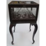 An Edwardian patent harlequin sherry cabinet in carved mahogany with four bevelled glass panels.