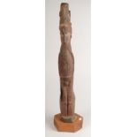 A Papua New Guinea carved wood figure of a naked man with a high bird headdress, height 71cm.