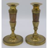 A pair of 19th century Empire style brass candlesticks,