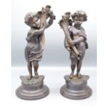 A pair of bronze figures of cherubs, signed 'Rousseau', height 40cm and 38cm.