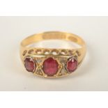 An Edwardian 18ct gold ring set with three rubies and four small diamonds.