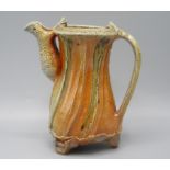 A Ruthanne Tudball orange glazed stoneware water jug, height 15cm.