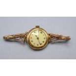 A ladies 18ct. gold cased wristwatch with fifteen jewel movement and white enamel dial on 18ct.