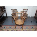 A set of four spindle back kitchen chairs each with a circular seat.