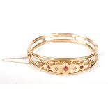 A 9ct gold Edwardian bangle set with red and white stones, 9.9g.