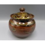 A Ray Finch Winchcombe Pottery jar and cover, the brown ground with abstract designs, height 11.5cm.