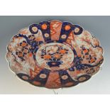 A large Japanese Imari porcelain charger, 19th century, decorated with a central vase of flowers,