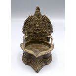 An Indian bronze wick lamp decorated with a seated goddess flanked by elephants, height 13.5cm.