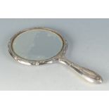 An Edwardian silver mounted hand mirror by a garden wall after Kate Greenaway.