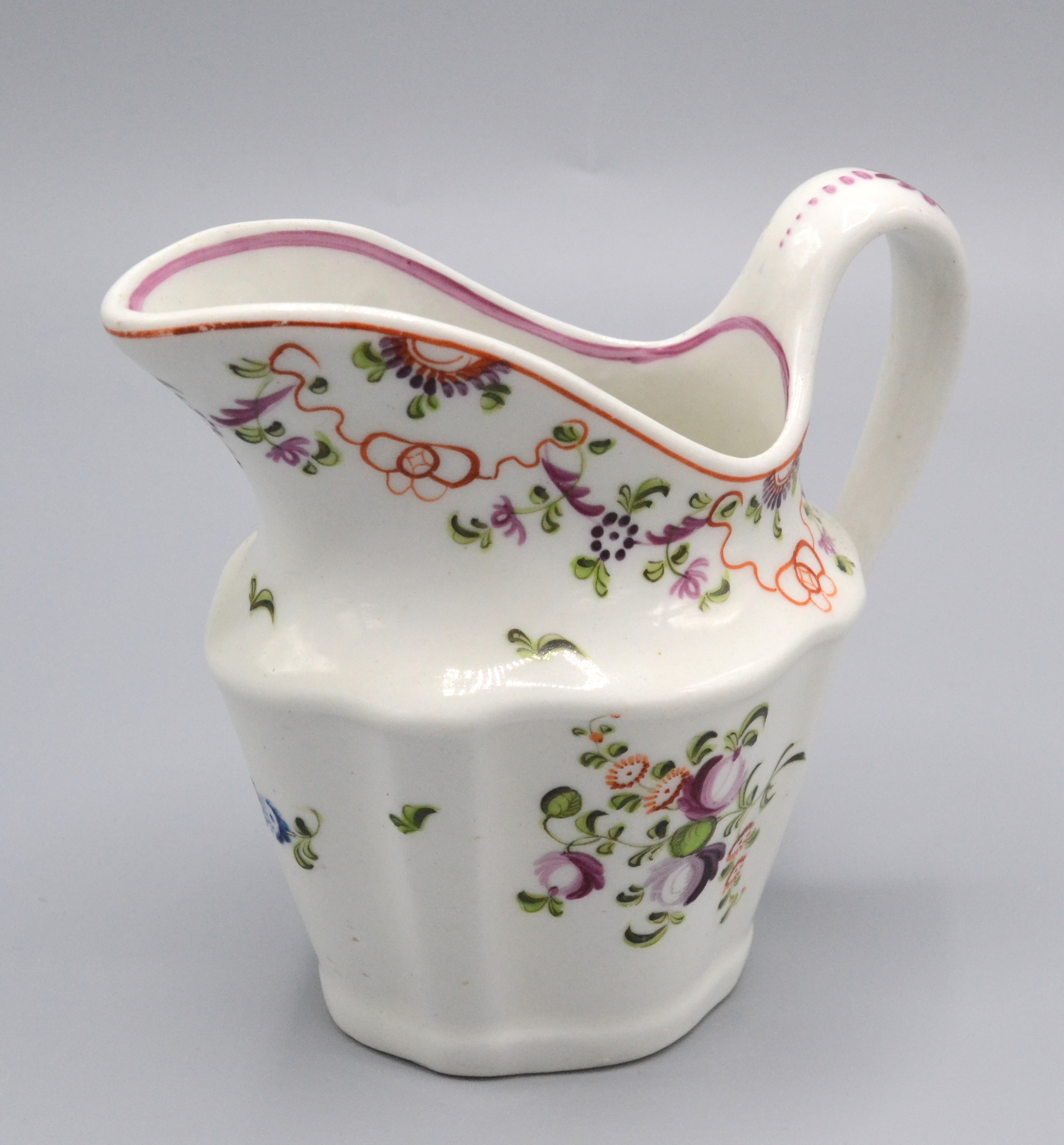 A Newhall porcelain helmet shape cream jug, circa 1790, painted with floral sprays,