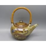 A Seth Cardew Studio Pottery teapot, decorated with stylised fish, with a bamboo swing handle,
