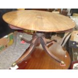 A George III mahogany breakfast table, the circular top on a turned stem and downswept supports,