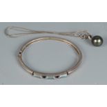 A silver and tourmaline bangle together with a 11mm black pearl pendant on silver snake chain.