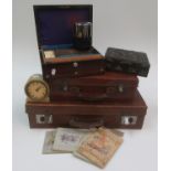 Two leather suitcases, two work boxes, a mantel clock, money box and four cigarette card albums.