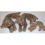 Three Steiff recumbent tigers, the larger with button in left ear, the largest 14" long.
