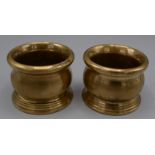 A pair of Chinese polished bronze censers, each with a bulbous body and stepped base, diameter 7.