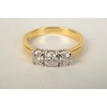 A three stone diamond ring in 18ct gold.