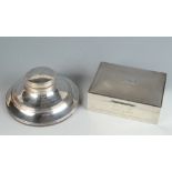 An engine turned silver cigarette box and a silver Capstan inkwell.