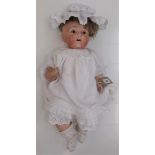 A Heubach porcelain head doll, the head with sleep eyes, open mouth and teeth,