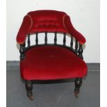 A Victorian ebonised tub armchair, with eleven turned spindles, the padded back,