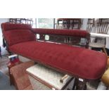 A Victorian carved walnut chaise longue upholstered in red fabric.