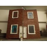A painted plywood dolls house "Poly Villa" with glass windows and containing four rooms.
