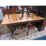 A Jacobean style light oak, draw leaf dining table on a pair of carved cup and cover supports,