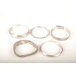 Five silver bracelets.