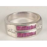 An 18ct white gold contemporary ring set with two rows of calibre set rubies each shoulder with a