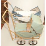 A small tin twin dolls pram together with a small plastic covered dolls pram,