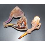 Two meerschaum pipes, one carved with a lady's head.