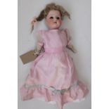 A small shoulder plate porcelain head doll, the head with fixed eyes, open mouth and teeth,