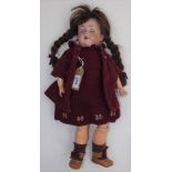 A porcelain head doll on a composition bent limb body, the head with open mouth,