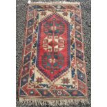 A Turkish rug, the ivory field with a red central medallion, within two borders, 130 x 77cm.